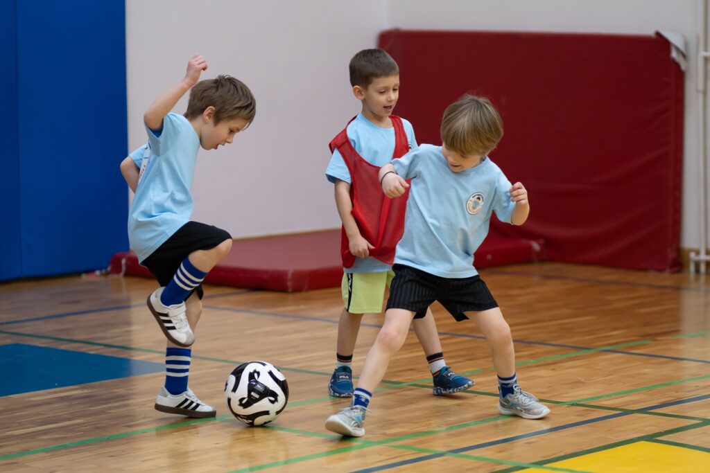 Gra w parach i małej grupie podczas treningu piłki nożnej – dzieci uczą się współpracy w grze zespołowej